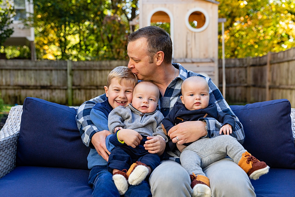 Father cuddling his children in a Boston backyard family photo session